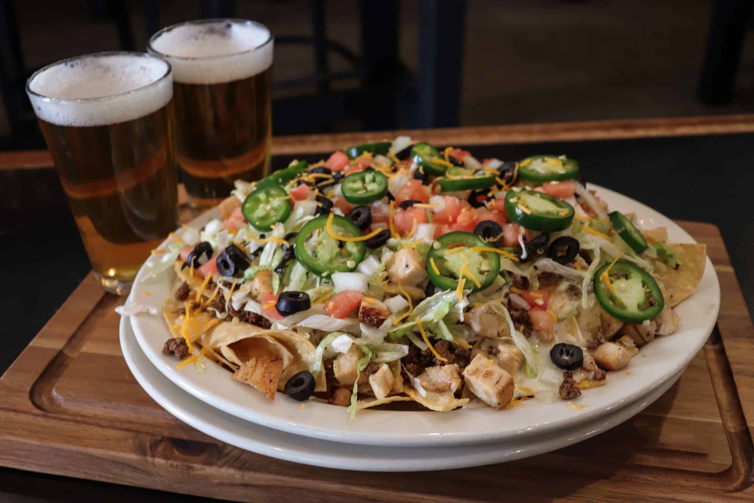 nachos with lots of ingredients and beer